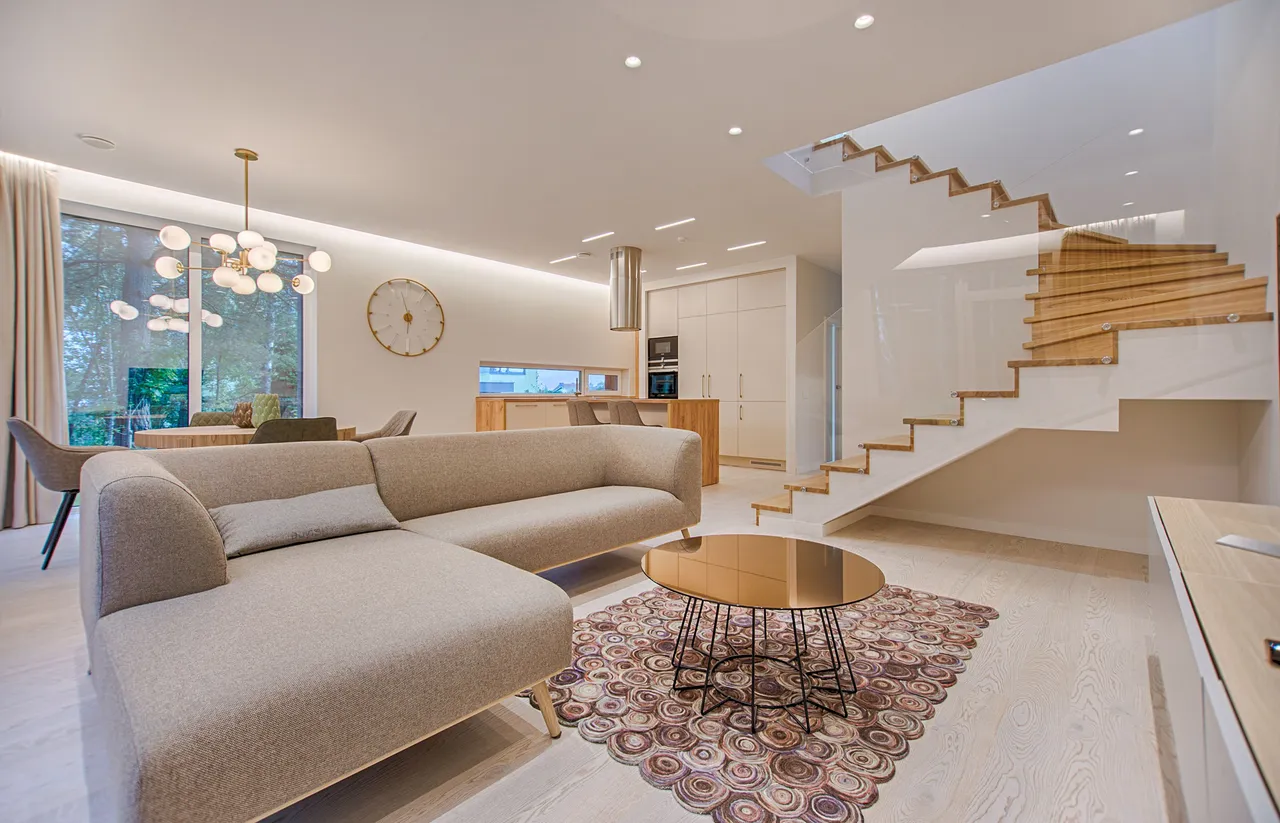 A light-filled living room with a neutral sofa and wood accents